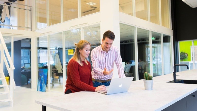 Opdrachtgever en freelancer bekijken samen een urenstaat