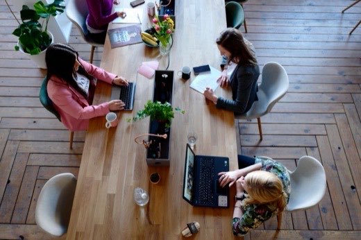 Werkplek van bovenaf met laptop en notitieblok