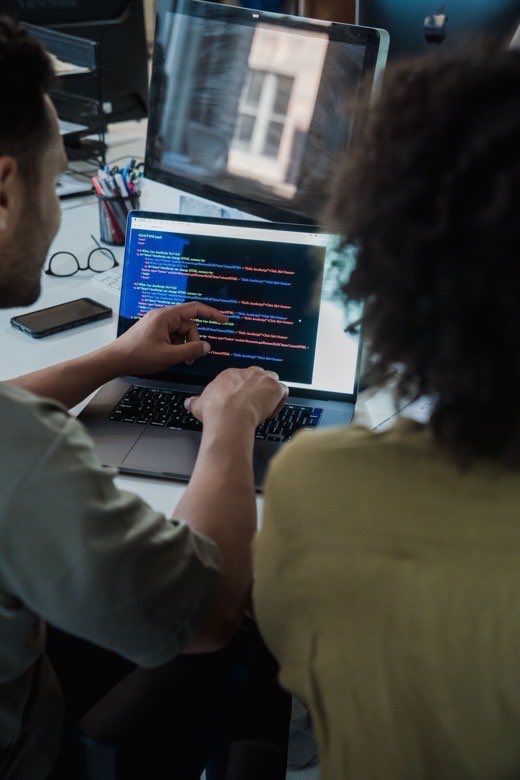 Developer aan het werk achter twee schermen